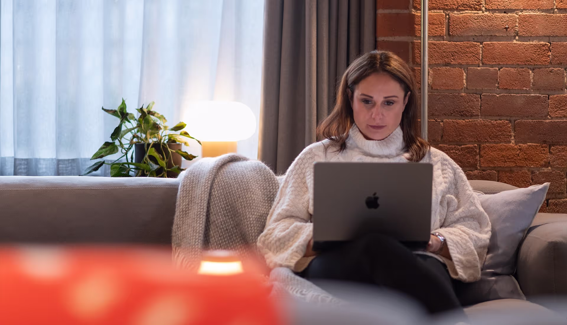 Women sitting on sofa typing a message to ollo living.