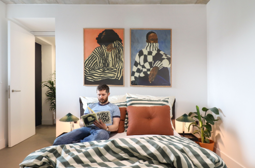 Man sat on bed reading book 